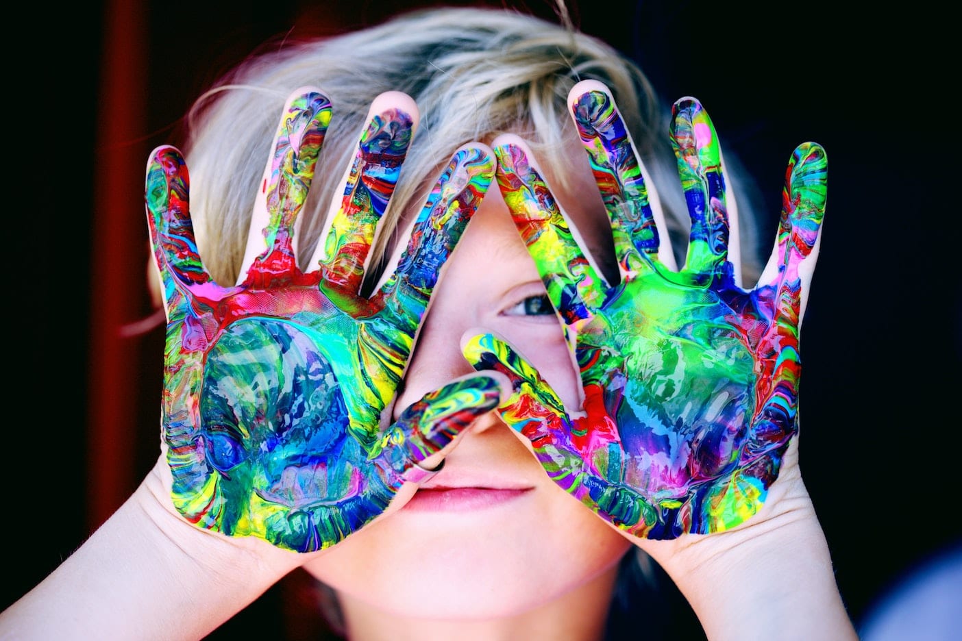 Young child exploring colorful paint