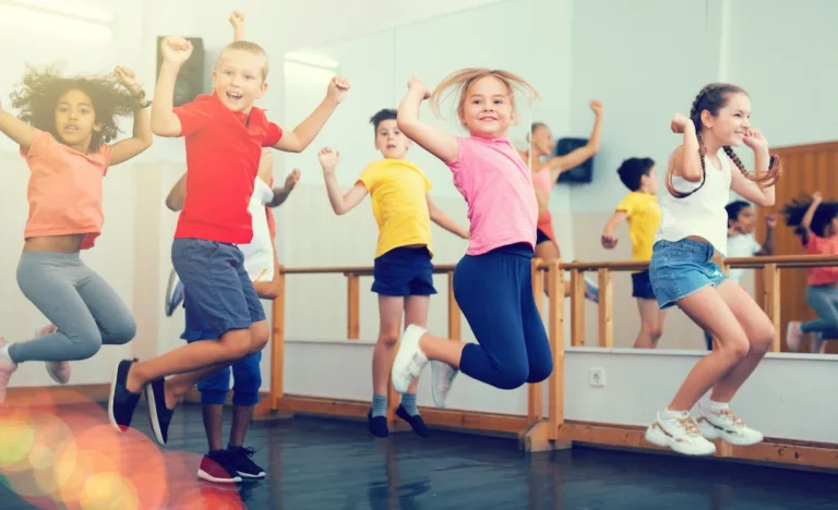 Portrait of satisfied boys and girls jumping having fun after dance class